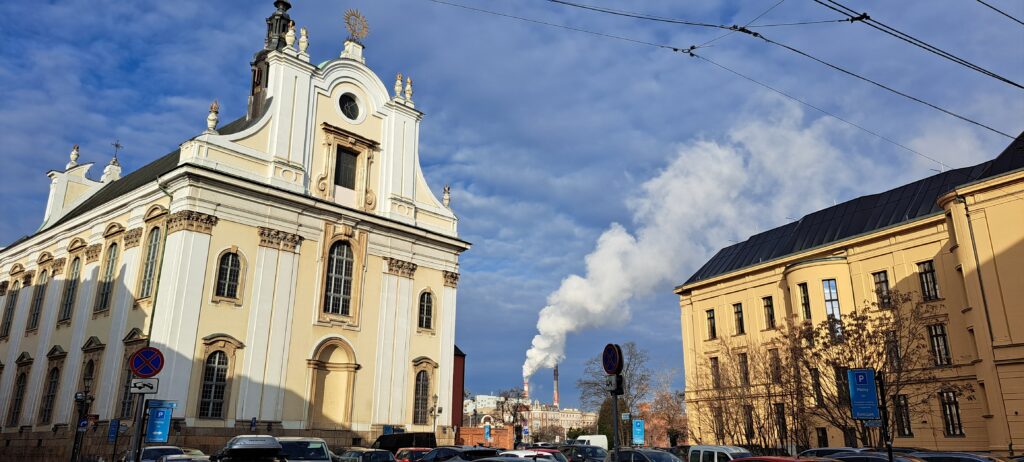 Dampfende Schornsteine einer Energieversorgers im Hintergrund, vorne alte Unigebäude