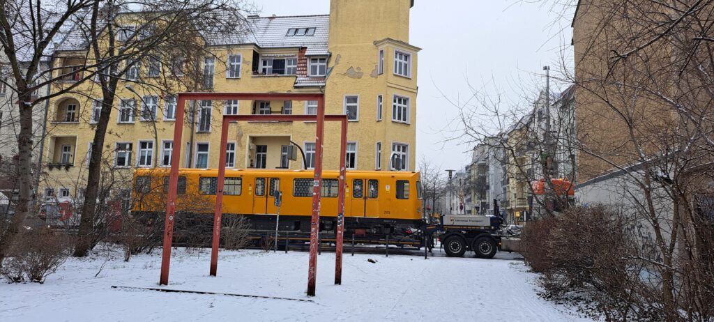 Ein U-Bahn Waggon fährt auf einem LKW vorbei