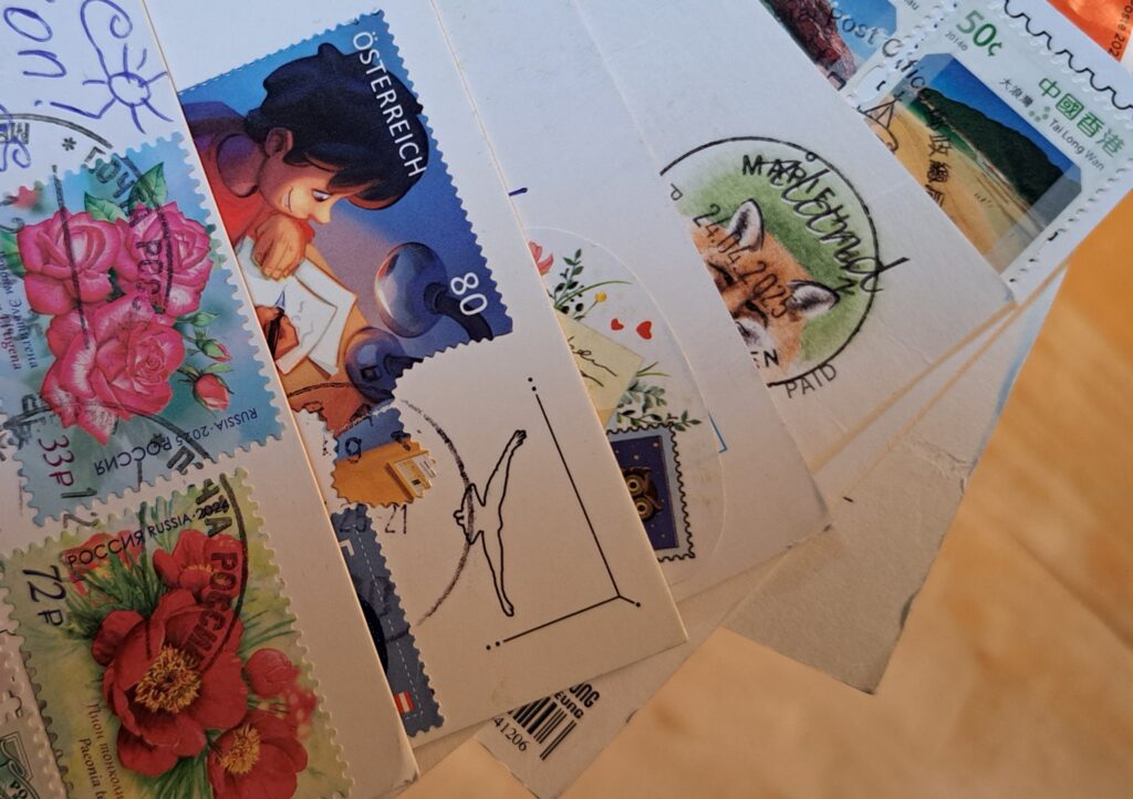 Postkarten werden so als Fächer gehalten, dass die Briefmarken zu sehen sind