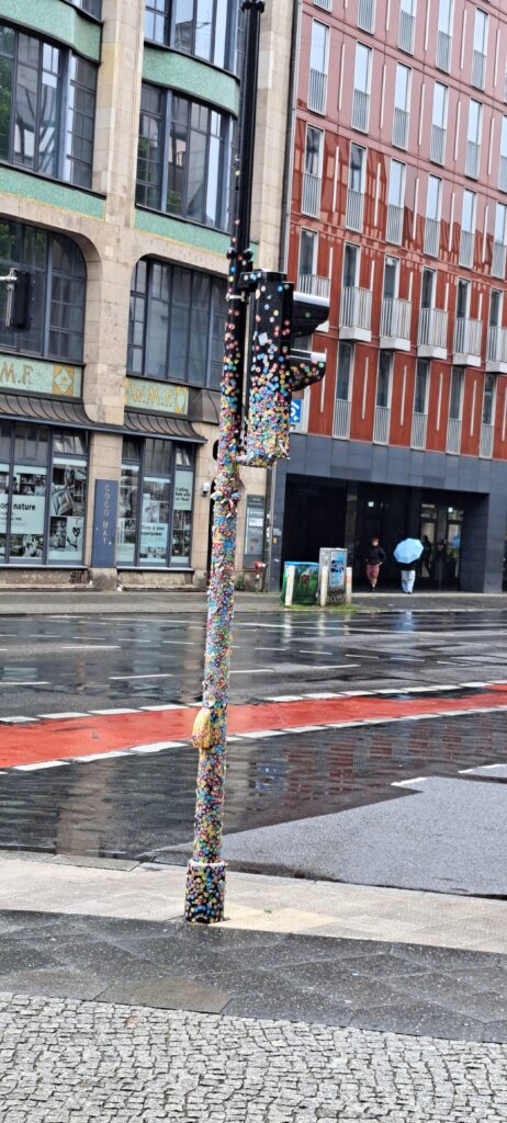 Eine Ampel, die mit den Eintrittskartenaufklebern des Museums von oben bis unten beklebt ist.