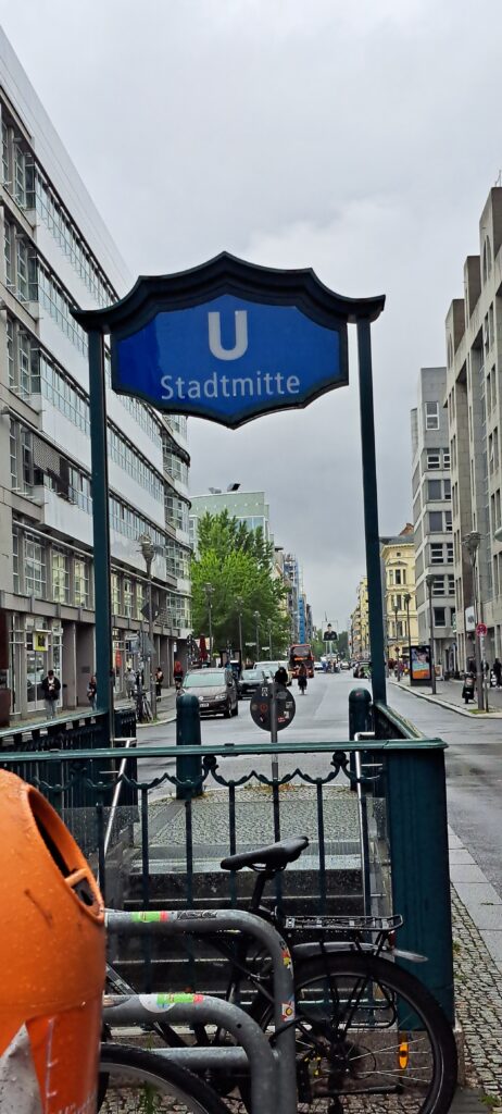 Vorne Eingangsschild U-Bahn Stadtmitte, hinten erkennbar Checkpoint Charlie