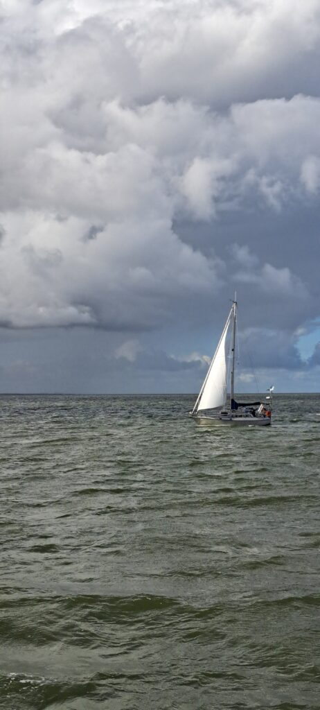 Ein Segelschiff, dunkles Nordseewasser, dunkle Wolken am Himmel