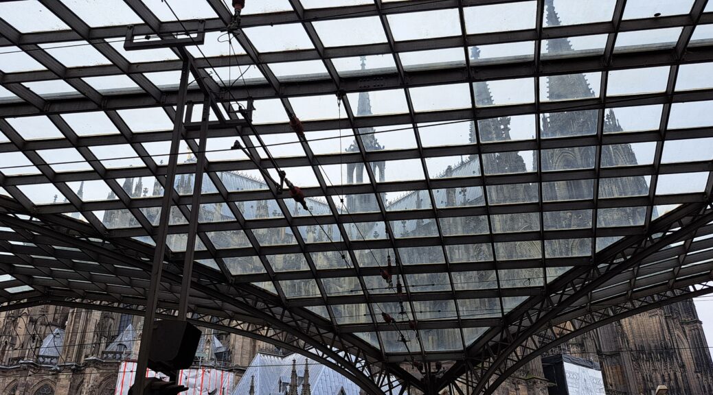 Blick von innen durchs Bahnhofsdach auf den Kölner Dom