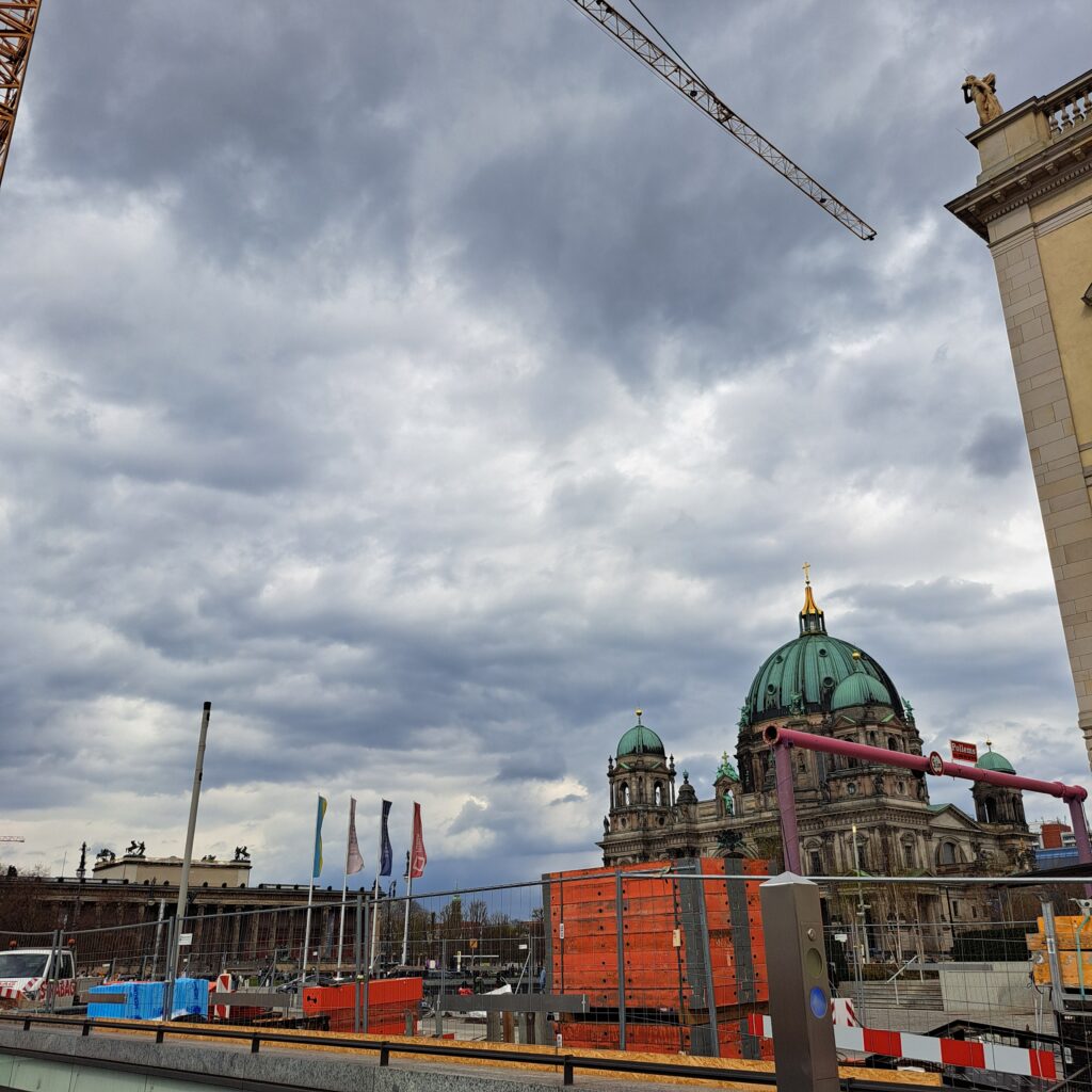 Blick auf den Berliner Dom, im Vordergrund Baustellengeräte und ein Kran