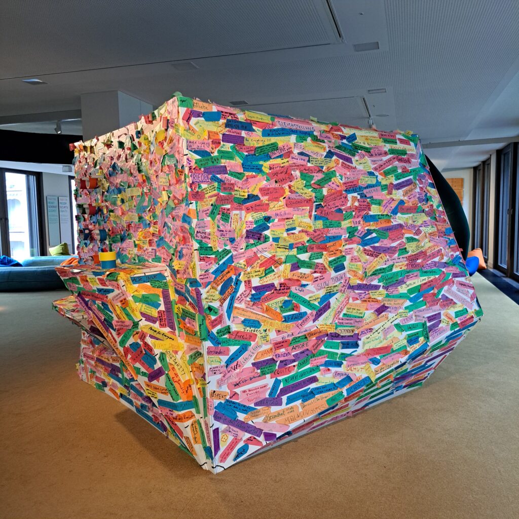 Würfel, auf den Ausstellungsbesucherinnen ihre Wünsche und Gedanken zur Ausstellung schreiben können.